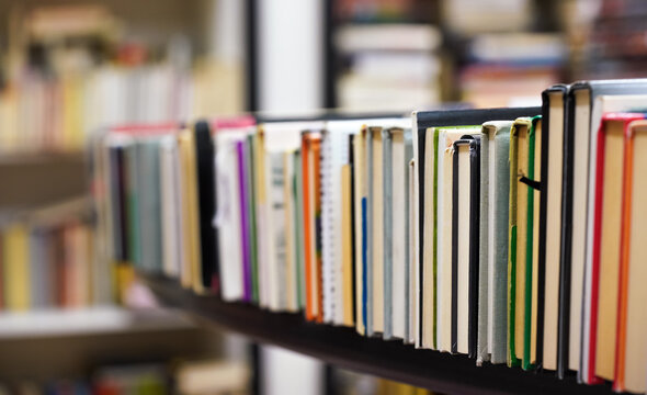 Row of many old used books displayed at local antiquarian bookshop, shallow depth of field photo only cover in focus