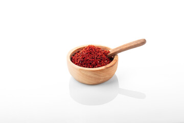 Chili pepper flakes. Chili pepper flakes in wooden bowl, on white background.