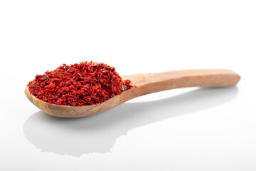 Chili pepper flakes. Chili pepper flakes in wooden spoon, on white background.