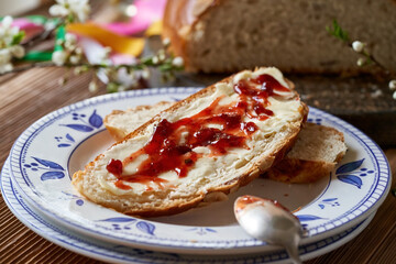 Slice of mazanec, traditional Czech sweet Easter pastry, similar to hot cross bun, with butter and marmalade