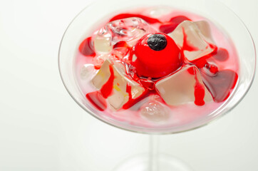 Halloween drink in a martini glass based on vodka, cream liqueur and grenadine with an edible decorative element in the shape of an eye