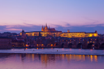 Obraz premium Prague at night along the river with Cathedral and Castle lit up (Czech Republic)