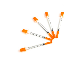 Five insulin syringes isolated on white background.