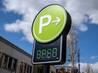 view of a lime green digital parking sign for a parking garage in a shopping district downtown