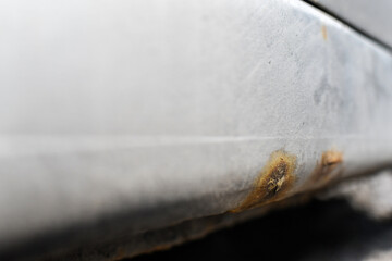 Signs of car corrosion or rust appearing on the bottom of the car. 