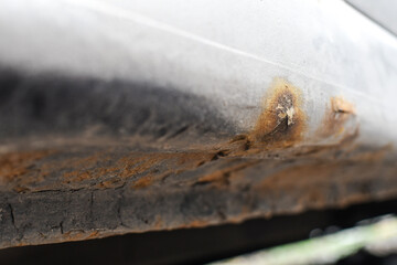 Signs of car corrosion or rust appearing on the bottom of the car. 