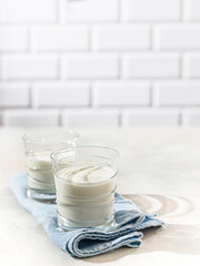 Fermented drink kefir, yogurt in a glass jar on a light background. Probiotic cold fermented dairy drink. Healthy gut flora concept.