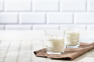 Fermented drink kefir, yogurt in a glass jar on a light background. Probiotic cold fermented dairy drink. Healthy gut flora concept.