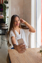 young woman taking a selfie with her cell phone