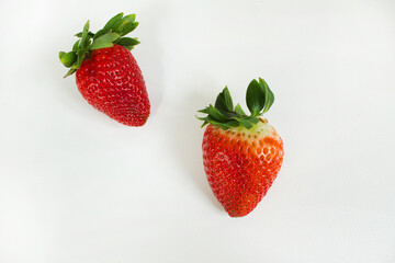 Two red ripe fresh strawberry on white background top view