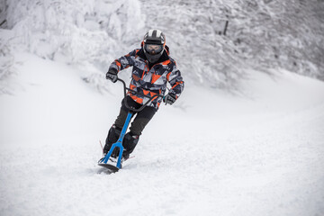 Fototapeta na wymiar Riding downhill with a snowscoot (snowbike)