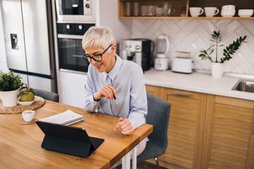 Beautiful senior manager having online meeting from home.