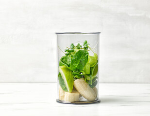 banana and various green vegetables in blender container