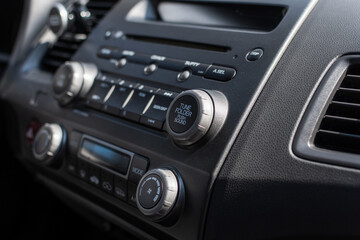 Obraz na płótnie Canvas Close up of a car dashboard with a radio tuner. Selective focus.
