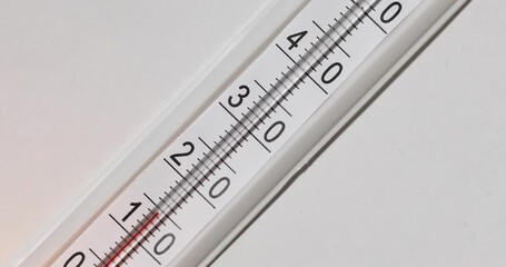 Thermometer on a white background. The temperature on the thermometer rises and it breaks down. The red liquid is methylcarbitol. - Powered by Adobe