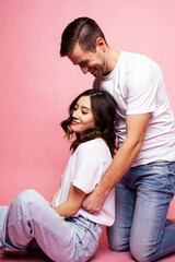 young cheerful caucasian couple together having fun on pink background, guy ang girl modern relationship, lifestyle people concept