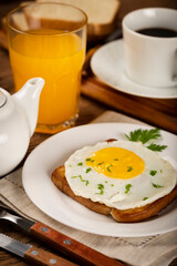 Breakfast with juice, coffee and toast with fried egg.