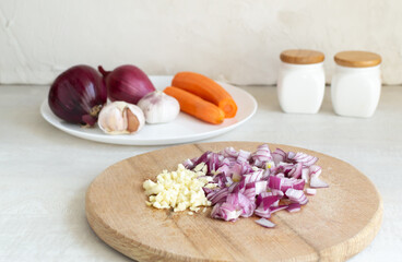 Fototapeta na wymiar How to make a cutlet for veggie chickpea burger at home. Step by step instruction. Step 4. Chop the red onion into small pieces and chop the garlic. Fry until soft in olive oil.