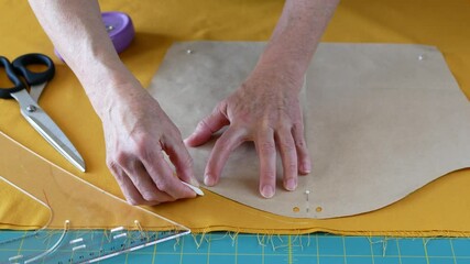 Tailor draws sewing pattern on the fabric adding seam allowances. Concept of sewing project, dressmaking