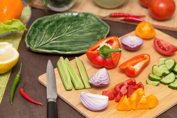 Different vegetables for cooking healthy vegetarian vegan diet food. Cutting vegetables on wooden board on kitchen