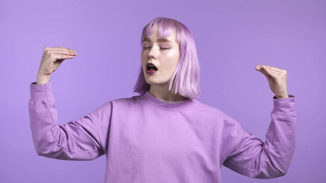 Pretty unusual woman showing bla-bla-bla gesture with hands isolated on violet background. Empty promises, blah concept. Lier.