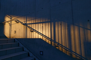 オレンジ色の夕日の光で照らされた外階段と手すり