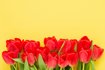 Red tulips bouquet on a yellow background. Mothers Day, Valentines Day concept.