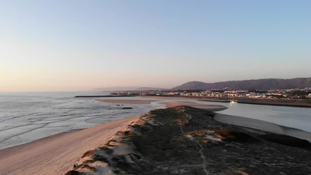 DRONE AERIAL FOOTAGE: Northern Litoral Natural Park in Ofir, Fao, Esposende, Portugal at sunset. The two sides of Restinga de Ofir. One facing the ocean, the other the estuary of C&aacute;vado River.