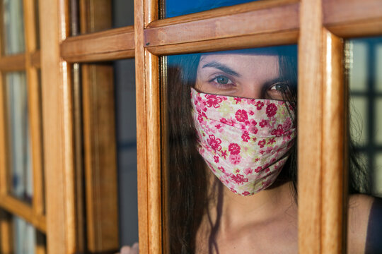 mujer barbijo ventana mirada asilada 