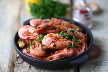 Shrimp in shells in a frying pan. Delicious fried prawns with spices.