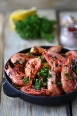Shrimp in shells in a frying pan. Delicious fried prawns with spices.