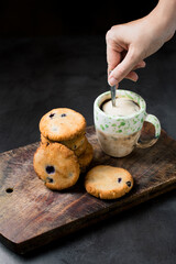 Blueberry Scones with woman's hand stirring a black coffee. Healthy food concept. Black stone texture background