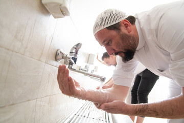 a group of Muslims take ablution for prayer. Islamic religious rite