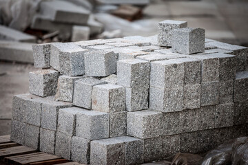 Pellet with granite block cobblestone paving stones, stacked, ready to be used on a construction site, a road and sidewalk renovation site, planning to fit and lay new tiles. 