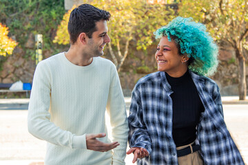 portrait of multiethnic couple chatting happily walking in the city