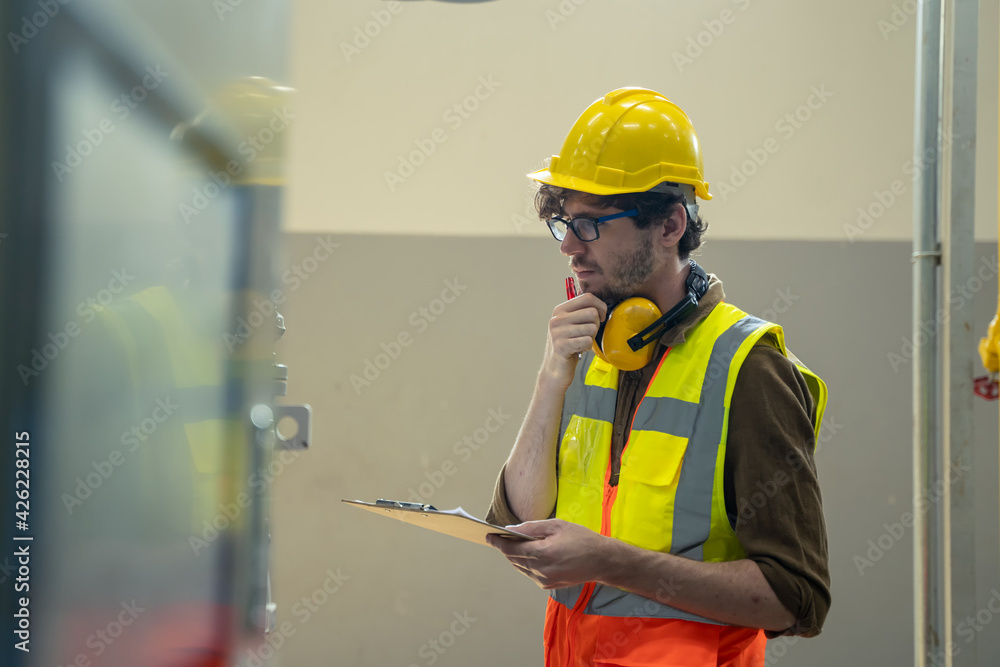 Poster technician engineer checking controls system for security functions in service room at factory,heati
