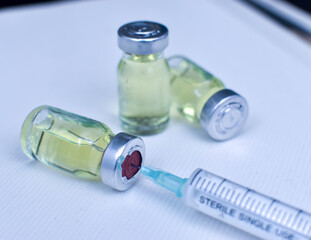 Vial of drugs injection or vaccine with syringe needle on a white background for cure and prevention of sickness 