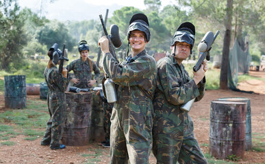 Fototapeta premium Two happy paintball players in full gear having fun before game outdoors