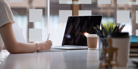 Close up hand of female graphic designer sketching on her project with digital teblet at modern...