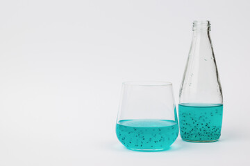 A bottle and a glass with an exotic cocktail on a light background.