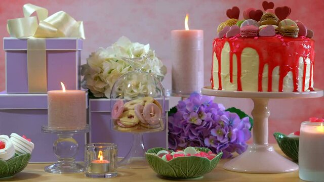 4k Mother's Day or Birthday party table with stack of gifts, cookies, flowers, and showstopper drip cake. Dolly reveal to static shot.