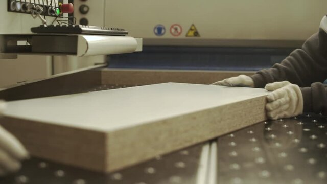 Close up industrial operator work with melamine plank in factory