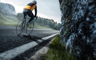 Fototapeta na wymiar Rennradfahrer auf einer Landstraße in den Bergen 