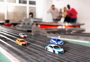 Toy remote control racing bright multicolored cars on the track and enthusiastic players