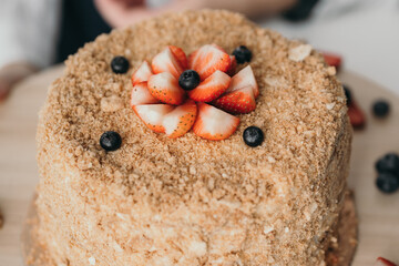 Fragrant homemade honey cake with berries. Homemade confectionery with sweets.