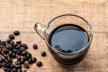 A cup of black coffee on wooden background.