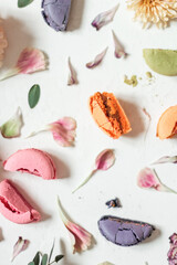 Abstract composition of macaroon halves and flower petals on a white background