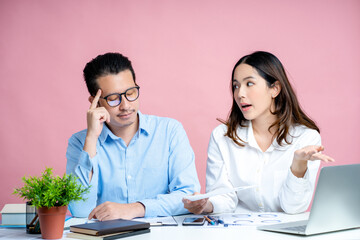 Young Asians are having problems with their prepared projects..Isolated on pink background Studio.