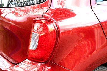 Car detail series: Close-up of the red tail light, parked under the shadow of a tree.