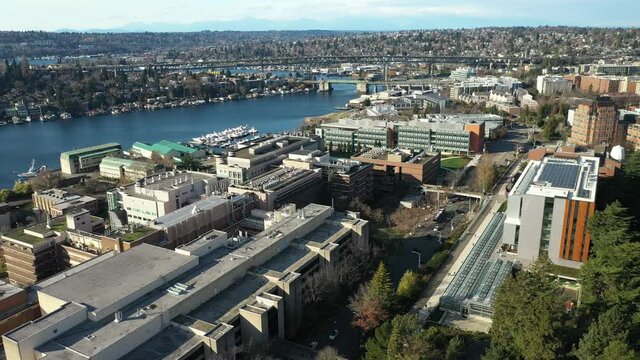 Cinematic sunset aerial drone clip of houseboats on Lake Union, the Ship Canal Bridge with highway I-5, Capitol Hill, Eastlake, Portage Bay near downtown Seattle in King County, Washington